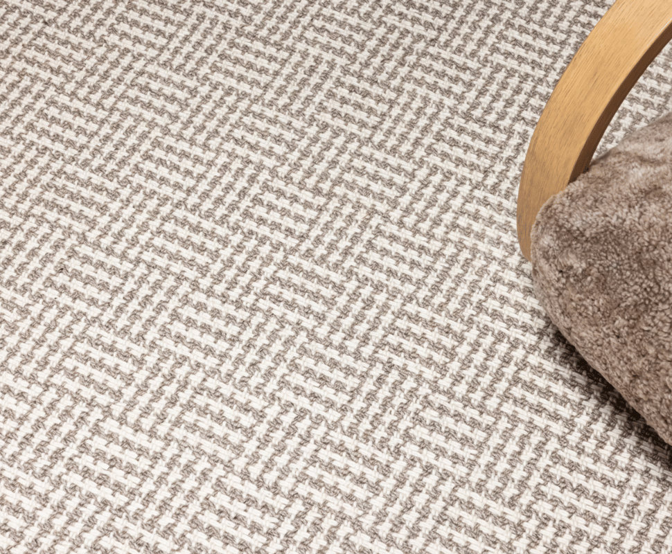 Modern lounge chair arm styled over a neutral Sandstone basketweave flatweave New Zealand wool carpet.