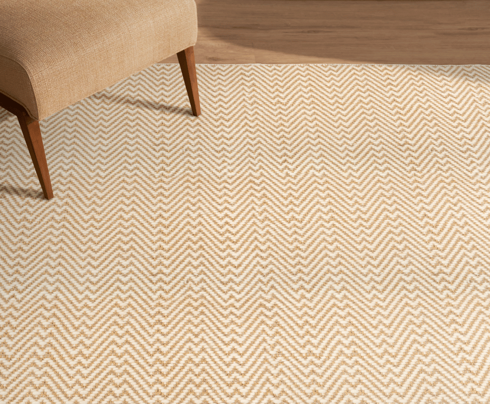 Warm modern seating nook with an upholstered lounge chair set over a Kravet Durban Natural chevron carpet.