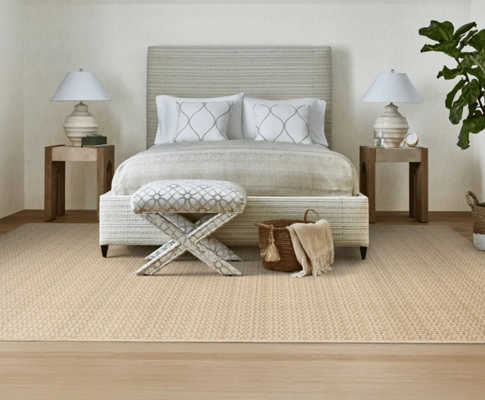 Serene master bedroom layout with matching bedside lamps and a tufted bench on cream grid-pattern carpet.