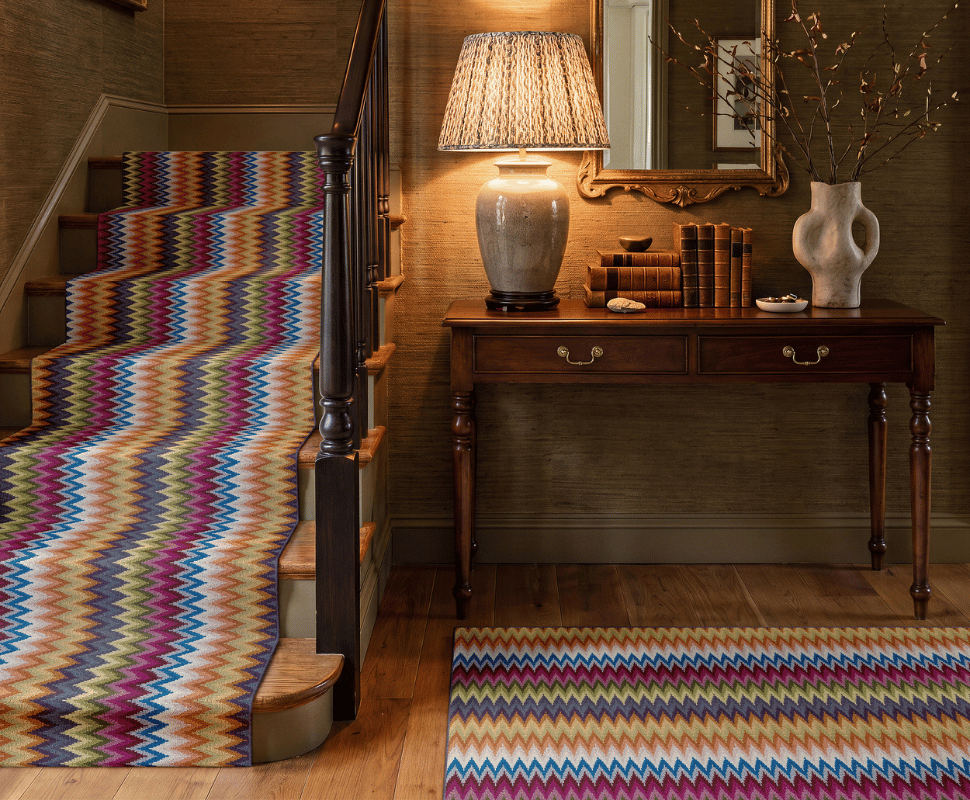 Grand foyer staircase and matching hall runner styled in colorful zig-zag wool broadloom carpet.