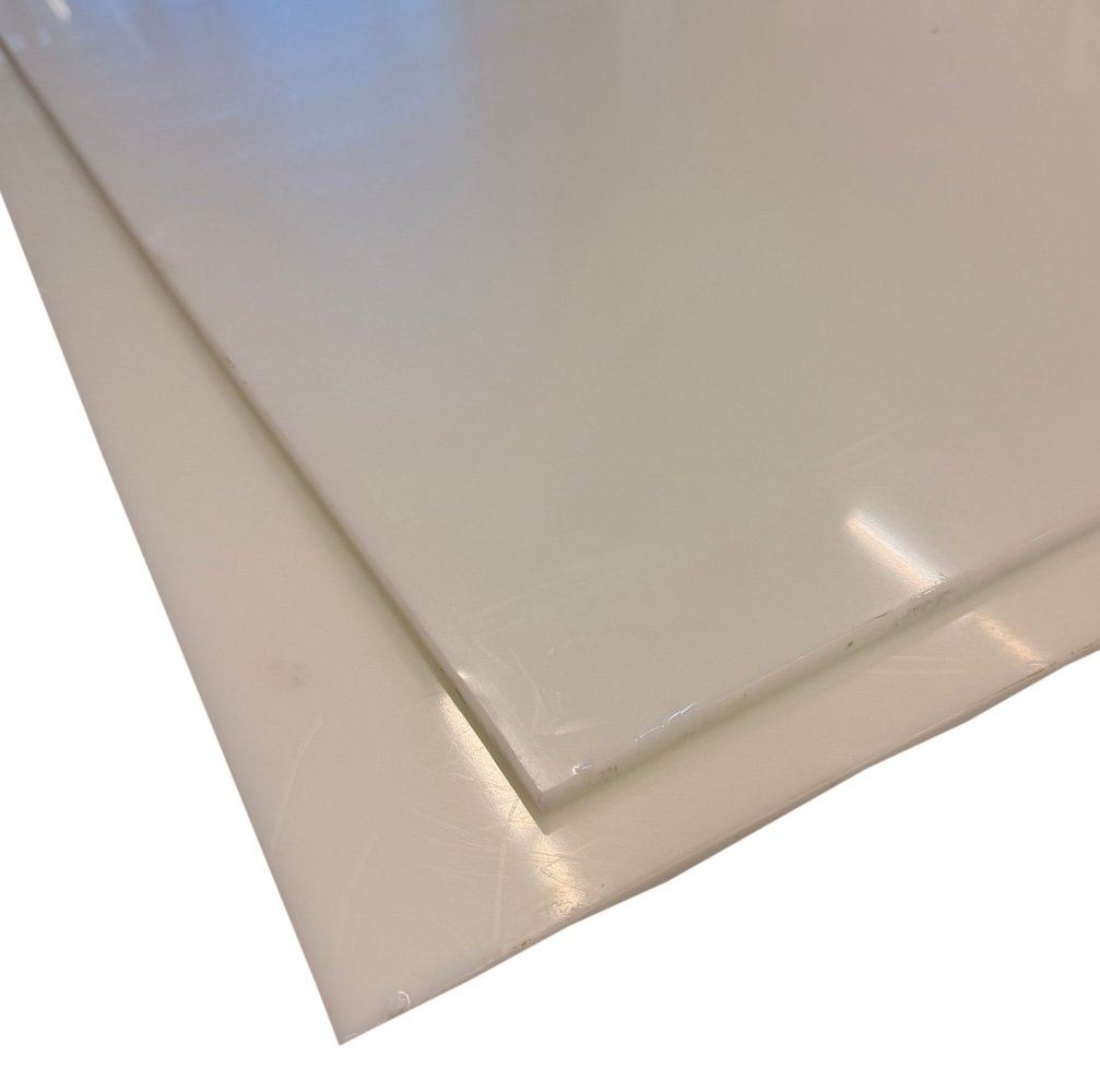Natural white HDPE plastic sheet angled to show matte surface and cut edge thickness on white background